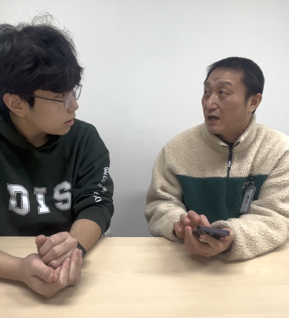 Oliver discussing his Braille Learning App with the team leader at Daegu Braille Library